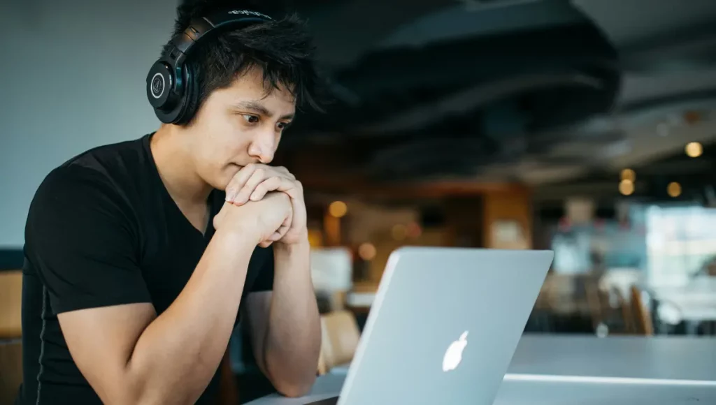 Man using a laptop with headphones on