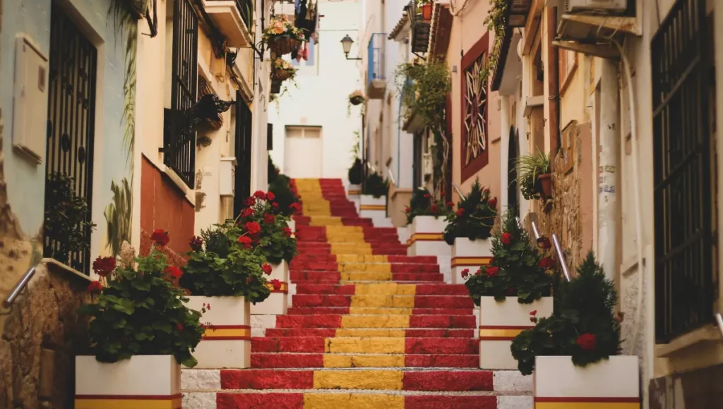 Spanish flag colors painted on a stone staircase in a narrow European alley